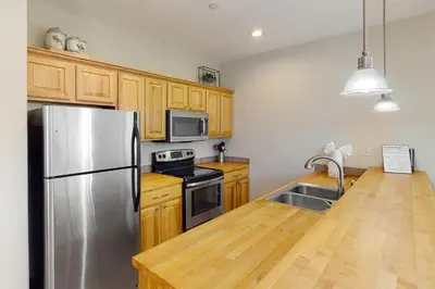 a kitchen with wooden cabinets and a stainless steel refrigerator at Blue River Bliss in Silverthorne