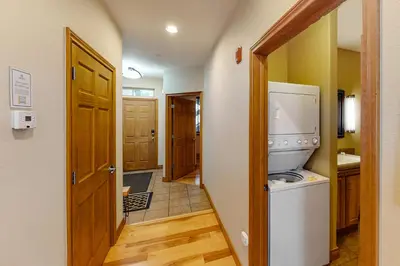 a kitchen with a washer and dryer next to a door at Blue River Bliss in Silverthorne
