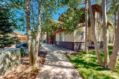 a house with trees in front of a sidewalk at Blue River Bliss in Silverthorne