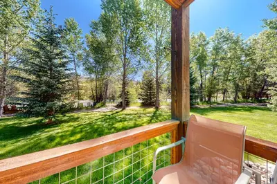 a porch with a chair and a view of a yard at Blue River Bliss in Silverthorne