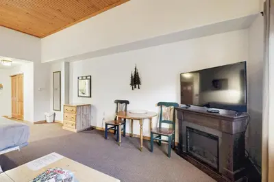 a living room with a television and a table with chairs at Gateway 5059 in Keystone