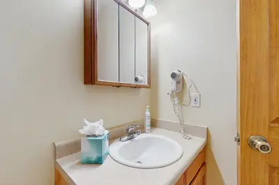 a bathroom with a sink and a phone on the wall at Riverview Condo #4 in Grand Lake