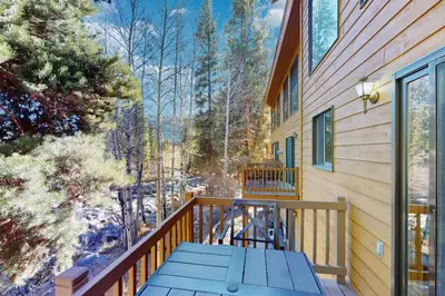 a deck with a blue picnic table on a house at Riverview Condo #4 in Grand Lake