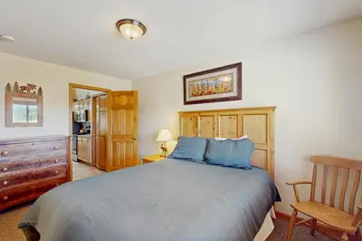 a bedroom with a large bed and a chair at Riverview Condo #4 in Grand Lake
