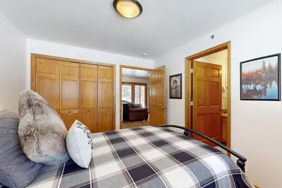 a bedroom with a bed and a living room at Riverview Condo #5 in Grand Lake