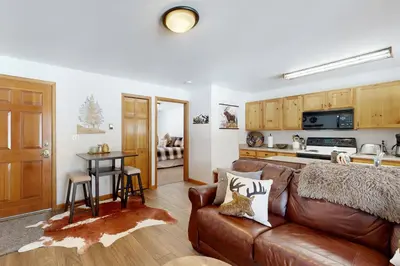a living room with a couch and a kitchen at Riverview Condo #5 in Grand Lake