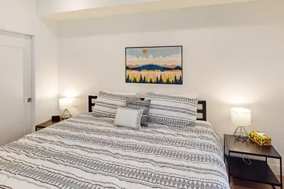 a bedroom with a bed with two lamps and a painting on the wall at Blue River Dream in Silverthorne