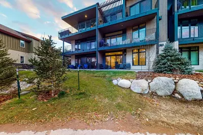 a building with a yard with trees and rocks at Blue River Dream in Silverthorne