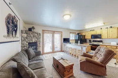 a living room with a couch and a table and a kitchen at Riverview Condo #7 in Grand Lake