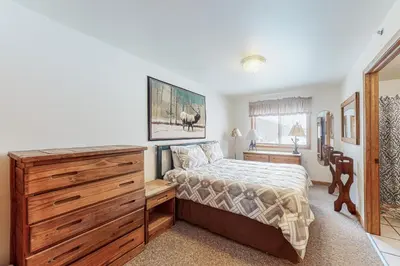 a bedroom with a bed and a dresser and a desk at Riverview Condo #7 in Grand Lake