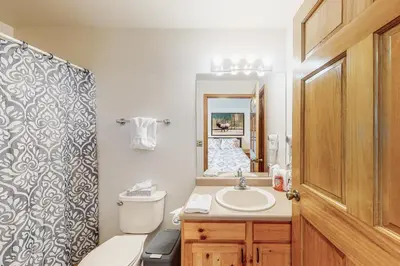 a bathroom with a toilet and a sink and a mirror at Riverview Condo #7 in Grand Lake