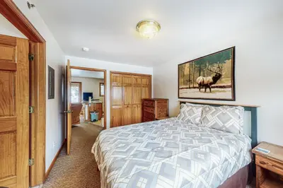 a bedroom with a bed and a painting of a deer at Riverview Condo #7 in Grand Lake