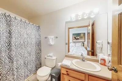 a bathroom with a sink and a toilet and a mirror at Riverview Condo #7 in Grand Lake