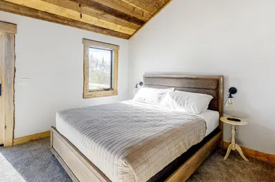 a bedroom with a bed and a window at Square House in Grand Lake