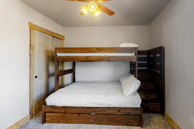 a bedroom with a bunk bed and a ceiling fan at Square House in Grand Lake