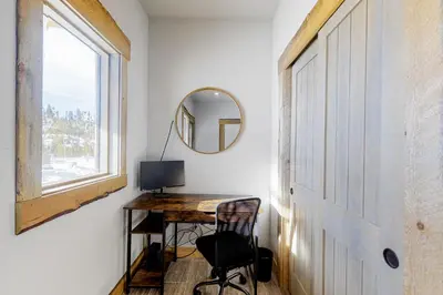 a room with a desk and a window and a door at Square House in Grand Lake