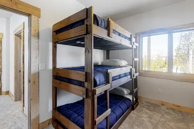 two bunk beds in a room with a window at Square House in Grand Lake