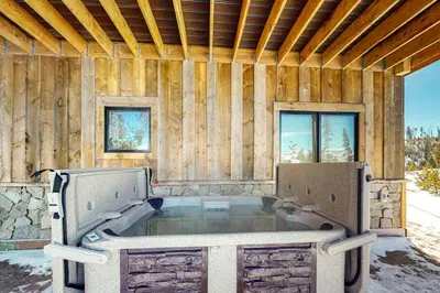 a hot tub in a room with wooden walls at Square House in Grand Lake