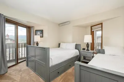a bedroom with two beds and a balcony at Cozy Corner in Winter Park