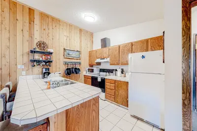 a kitchen with wooden cabinets and a white refrigerator at Cozy Corner in Winter Park