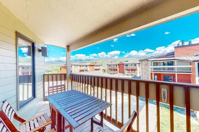 a porch with a blue table and chairs on a balcony at Cozy Corner in Winter Park