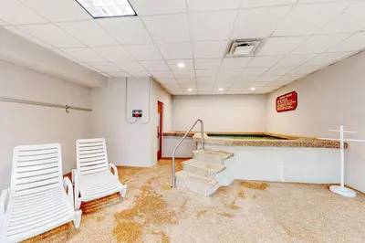 an empty room with two chairs and a cross on the wall at Cozy Corner in Winter Park