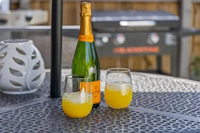 two glasses of orange juice and a bottle on a table at Stylish Church Conversion Walk to LoHi in Denver