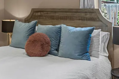 a bed with blue pillows and a brown ball on it at Stylish Church Conversion Walk to LoHi in Denver