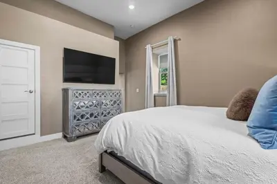 a bedroom with a bed and a flat screen tv at Stylish Church Conversion Walk to LoHi in Denver