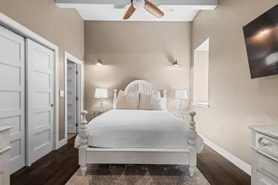 a white bedroom with a white bed and a ceiling fan at Stylish Church Conversion Walk to LoHi in Denver