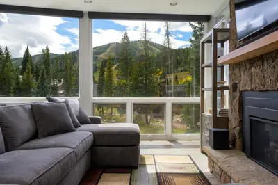 a living room with a couch and a large window at Riverside Retreat condo in Winter Park