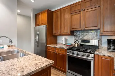 a kitchen with wooden cabinets and a stainless steel refrigerator at Riverside Retreat condo in Winter Park