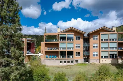 a large apartment building with balconies and trees at Riverside Retreat condo in Winter Park