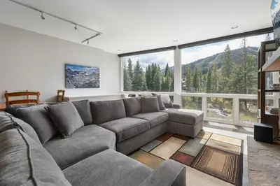 a living room with a couch and a large window at Riverside Retreat condo in Winter Park