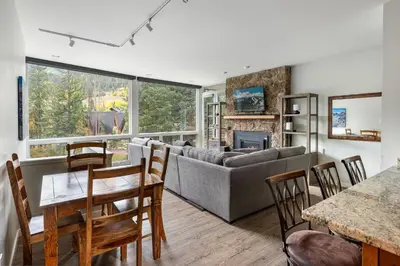 a living room with a couch and a table and chairs at Riverside Retreat condo in Winter Park