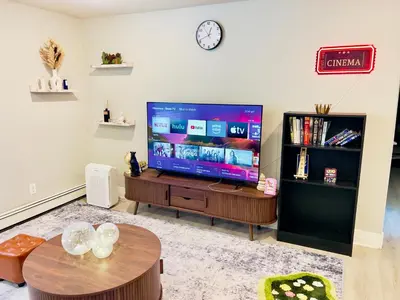 a living room with a large television and a table at Getaway Spot Close To Red Rocks, Denver & Mtns in Lakewood