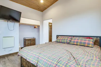 a bedroom with a bed and a flat screen tv at Grand Family Home with Deck and Trail Access in Fraser in Fraser
