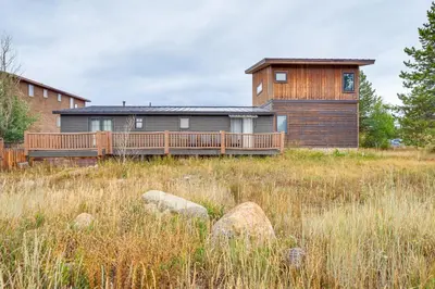 a house with a deck in a field at Grand Family Home with Deck and Trail Access in Fraser in Fraser