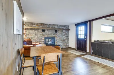 a living room with a table and a fireplace at Grand Family Home with Deck and Trail Access in Fraser in Fraser