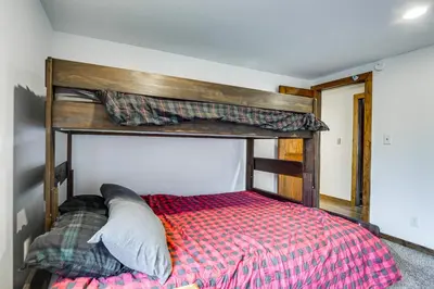 a bedroom with a bed with a wooden headboard at Grand Family Home with Deck and Trail Access in Fraser in Fraser