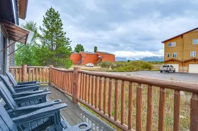 a deck with chairs and a fence and a house at Grand Family Home with Deck and Trail Access in Fraser in Fraser