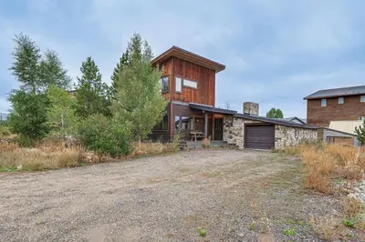 a wooden house with a large yard in front of it at Grand Family Home with Deck and Trail Access in Fraser in Fraser