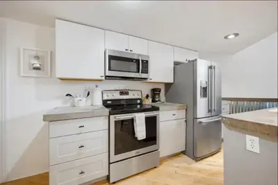 a kitchen with white cabinets and stainless steel appliances at Loft Retreat - King Bed&Balcony - Pet-Friendly 30 in Denver