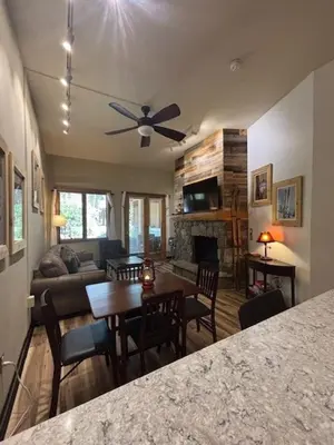 a living room with a ceiling fan and a table at Arapahoe Lodge-1BR and Murphy Condo -Kids Ski Free condo in Keystone