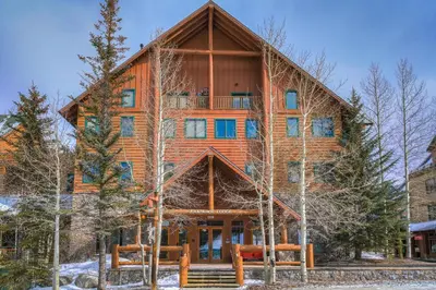 a large wooden house in the woods with trees at Arapahoe Lodge-1BR and Murphy Condo -Kids Ski Free condo in Keystone