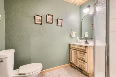 a bathroom with a toilet and a sink and a mirror at Cozy Wolfcamp Chalet with Hot Tub, Views with Fast Wifi in Bailey