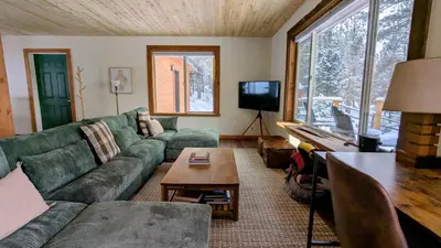 a living room with a green couch and a table at Cozy Wolfcamp Chalet with Hot Tub, Views with Fast Wifi in Bailey