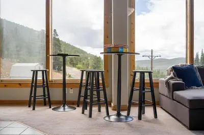 a living room with three bar stools in front of a window at Summit Condo at St. Marys in Idaho Springs