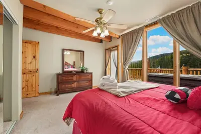 a bedroom with a red bed and a large window at Summit Condo at St. Marys in Idaho Springs