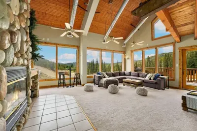 a large living room with a large stone wall at Summit Condo at St. Marys in Idaho Springs